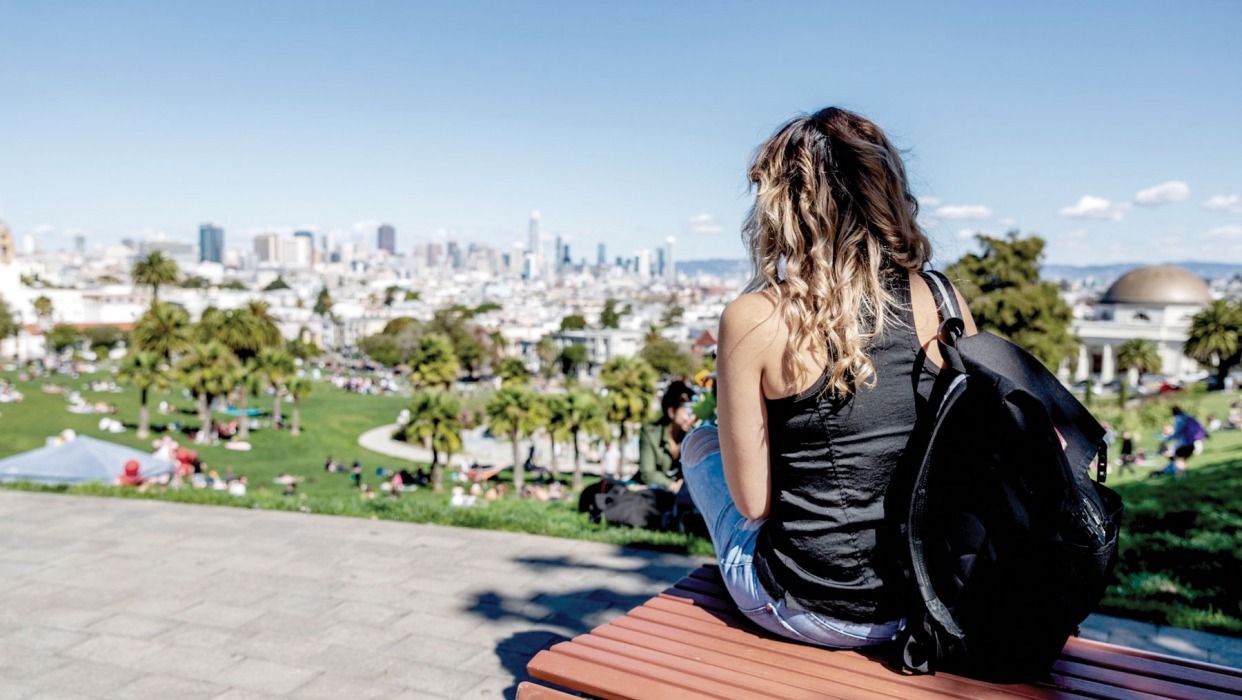 Girl looks at the San Francisco skyline from Dolores Park